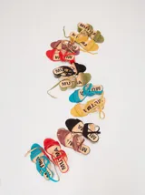 Sandalias de gamuza color bordó con taco bloque de charol, tiras con pespuntes artesanales en cuero y tira fina ajustable al tobillo.