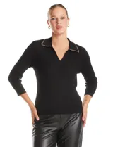 Buzo de tejido acanalado marca Rio & Rian, color negro, con cuello solapa decorado con una cadena metálica y escote en V. Presenta mangas tres cuartos y un ajuste al cuerpo.
