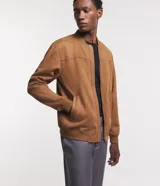 Chaqueta bomber azul marino lisa, con cierre frontal, cuello redondo y bolsillos laterales.