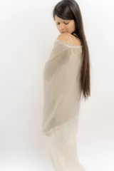 Blusa color beige de hilo con mangas amplias y terminación en picos.