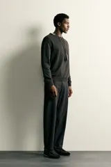 Pantalón regular fit de hombre color negro, confeccionado en tejido técnico ligero con cintura elástica, bolsillos frontales, bolsillos traseros de vivo y cierre frontal con cremallera y botón.