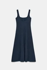 Vestido midi de color beige con escote cuadrado y tirantes anchos. Presenta un diseño entallado en el torso con costuras verticales marcadas y una falda con caída evasé.