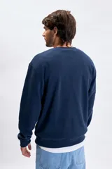 Buzo de polar azul marino con cuello redondo, mangas largas y puños elásticos. Presenta un bordado sutil en el pecho con la frase Jungle Bungle.
