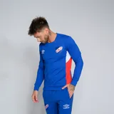 Buzo deportivo de manga larga, color azul, con cuello redondo y detalles en rojo y blanco en los laterales. Presenta el logo de Umbro y el escudo del Club Nacional de Football en el pecho.