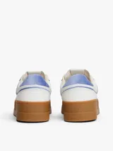 Zapatillas de corte bajo inspiradas en el baloncesto, con exterior de piel blanca, detalles en azul claro y suela de plataforma color caramelo. Presentan paneles de texturas a contraste y logo de la marca en el lateral.