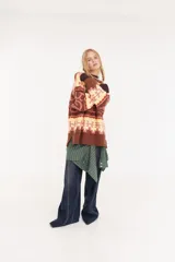 Sweater de punto oversize con diseño de intarsia geométrica y letras en tonos marrón, amarillo y rosado. Presenta cuello redondo, mangas largas y puños acanalados.