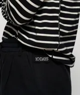 Pantalón ancho negro de corte relajado, confeccionado en mezcla de algodón y lino. Presenta cinturilla elástica de punto con cordón y trabillas, bolsillos laterales inclinados, etiqueta sobre el bolsillo izquierdo, minirayas bordadas bajo el bolsillo izquierdo y un bolsillo de ribete doble en la espalda.