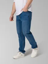 Pantalón de jean azul índigo con diseño clásico de cinco bolsillos, cierre de cremallera y botón metálico. Presenta corte de pierna delgada, remaches con logo en bolsillos delanteros y parche de marca en la cintura trasera.