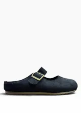 Zueco estilo bailarina color negro, confeccionado en gamuza, con tira en el empeine ajustable mediante hebilla metálica dorada.