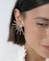 Caravanas tipo ear cuff con diseño de medio sol, compuestas por varillas metálicas plateadas, centro con strass y detalle de resina. Diseño liviano y brillante.