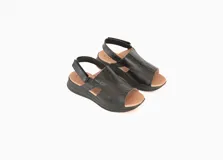 Sandalias de cuero negro con plataforma baja y tira trasera ajustable.