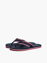 Ojotas Tommy Hilfiger con base azul marino y tiras de poliéster con el logo de la marca en blanco y rojo.