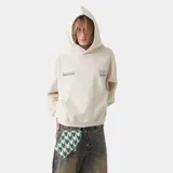 Hoodie de corte oversized color beige con capucha y bolsillo frontal tipo canguro. Presenta estampados gráficos circulares en color verde en la espalda con tipografía y logos de la marca.
