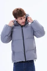 Campera puffer negra con capucha, cierre frontal y puños elásticos. Diseño acolchado con relleno térmico y exterior de nylon resistente.