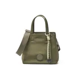 Cartera tipo tote de tamaño pequeño en color verde oliva, confeccionada en material textil. Presenta doble asa de mano, correa de hombro ajustable y un detalle decorativo de borla con cordones en el frente. Incluye un aplique circular con el logo de la marca en la parte inferior.