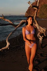 Conjunto de bikini color lavanda, compuesto por un top de estilo triangular con breteles regulables y una bombacha semivedetina con tiritas laterales ajustables.