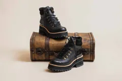 Botas de cuero negro con caña media, cordones y suela track.