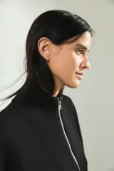 Campera deportiva de cuello alto con cierre frontal completo, mangas largas con puños elásticos y diseño holgado.