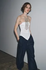 Top palabra de honor negro con escote recto, pliegues y bajo asimétrico.