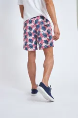 Short de baño con cintura elástica y cordón ajustable, confeccionado en tela ligera de secado rápido. Presenta un estampado botánico integral en tonos amarillos, blancos y azules, con dos bolsillos delanteros y uno posterior.