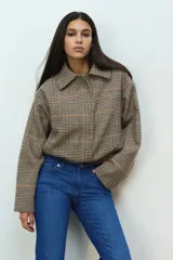 Pantalón jean de denim azul elastizado, de tiro bajo y corte ajustado con botamanga acampanada. Presenta diseño clásico de cinco bolsillos y cierre frontal con botón y cremallera.