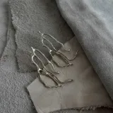 Aros colgantes con diseño orgánico inspirado en formas de coral, elaborados en metal con baño de plata y pernos de plata 925.