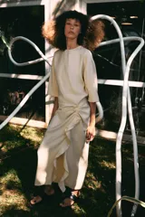 Vestido midi de Zara Woman Collection, confeccionado en mezcla de viscosa, con cuello redondo, manga corta y detalle de drapeado lateral con volado. Presenta bajo asimétrico y cierre en la espalda.