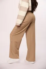 Pantalón sastrero de corte amplio y tiro alto, con bolsillos laterales y cierre frontal con botón.