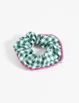 Gomita de pelo tipo scrunchie con estampado a cuadros verdes y blancos, y borde rosa.