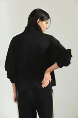 Campera deportiva de cuello alto con cierre frontal completo, mangas largas con puños elásticos y diseño holgado.