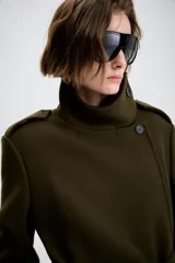 Abrigo de corte recto confeccionado en mezcla de lana, color verde oscuro. Presenta cuello subido, cierre frontal cruzado con botones, mangas largas con trabillas en los hombros, bolsillos delanteros y cinturón ajustable del mismo tejido.