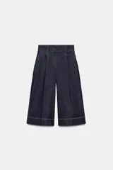 Bermuda de tiro alto en denim azul oscuro, corte ancho tipo culotte, con pinzas delanteras y pespuntes en color caramelo.
