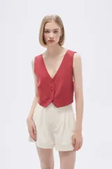 Top tipo chaleco de corte entallado, con escote en V y cierre frontal con botones a tono.