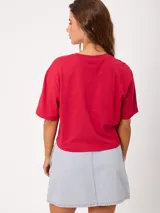 Remera color rojo de corte holgado, con cuello redondo y diseño estampado de una flor en el frente.