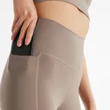 Calza deportiva de talle alto con bolsillos laterales, confeccionada en tejido elástico con tecnología de secado rápido.