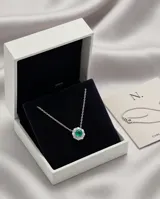 Collar de plata 925 con dije en forma de flor, compuesto por una piedra natural de turmalina verde central rodeada por pequeñas circonias brillantes.