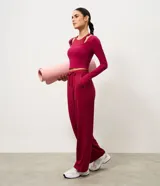 Pantalón deportivo femenino Get Over de corte recto, confeccionado en microfibra de poliamida y elastano, en color bordó. Cuenta con cintura elástica con lazo ajustable y bolsillos laterales.