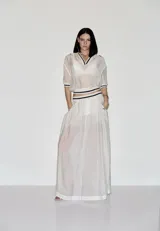 Falda larga blanca de silueta amplia y transparente, con cintura acanalada a rayas y bolsillos laterales.