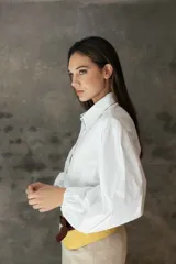 Camisa de manga larga con cuello clásico y botones frontales. Presenta un diseño de mangas amplias con volumen y puños elásticos, confeccionada en tejido liviano.