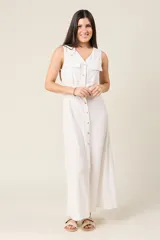 Vestido camisero largo sin mangas color negro, con cuello en V y cierre de botones delanteros. Incluye cinturón ancho a tono y bolsillos estilo safari en el pecho.