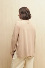 Sweater color beige de tejido de punto con cruce irregular y botones a contraste.