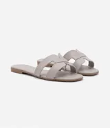 Sandalias planas Satinato de color tostado, con diseño de tiras cruzadas en forma de H en el empeine y puntera cuadrada.