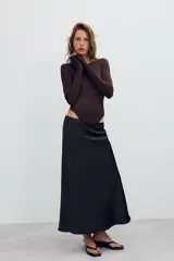 Falda midi de tiro alto y cintura elástica, confeccionada en tejido satinado de color negro.