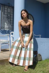 Falda larga de corte amplio con diseño de cuadros grandes en tonos marrón, verde oliva, celeste y blanco. Presenta cierre posterior y una estructura fluida.