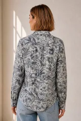 Camisa de manga larga con cuello clásico y cierre frontal de botones, con estampado botánico de hojas en tonos azules y blancos.
