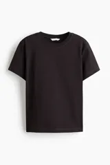 Remera oversized de algodón suave, color negro, con hombros levemente caídos y cuello redondo ribeteado.