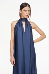 Vestido largo de viscosa color bordó, con cuello halter alto, corte holgado y volante fruncido en el bajo.