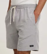 Bermuda de sarga con estampa rayada en color gris, de corte recto y largo por encima de la rodilla. Posee cintura elástica ajustable mediante cordón blanco y bolsillos laterales.