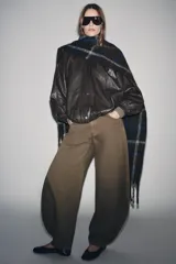 Chaqueta tipo bomber color marrón oscuro con efecto piel, cuello alto, manga larga abullonada y bajo elástico. Cuenta con bolsillos delanteros, forro interior a tono y cierre frontal con cremallera y botones a presión ocultos por solapa.