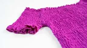 Top de color azul con diseño fruncido en toda la prenda, escote estilo hombros caídos y mangas cortas con terminación de volados.